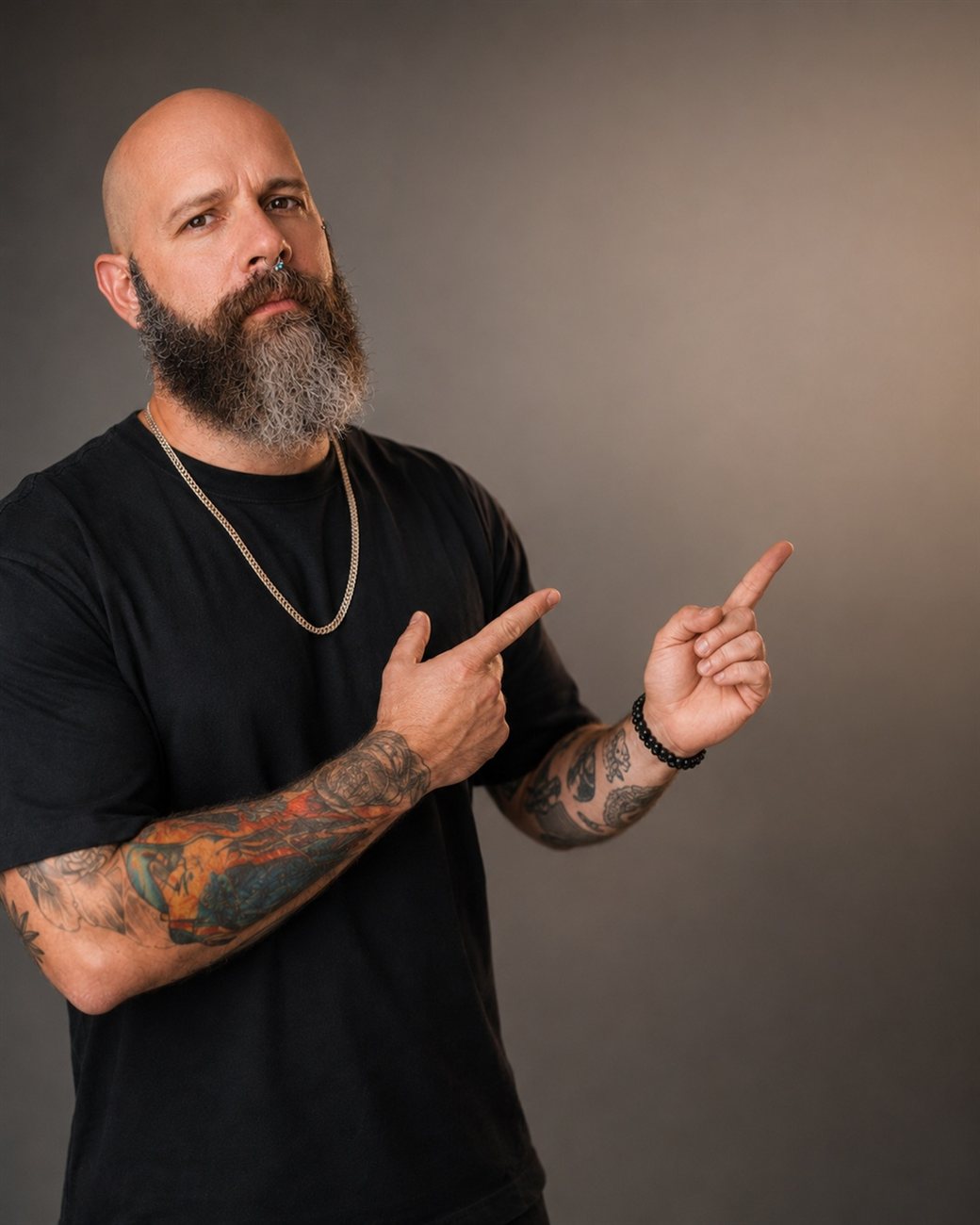 Gabriel Pires, tatuador, apontando em retrato de estúdio